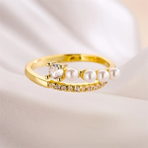 Vue macro d'une bague dorée double couche avec quatre perles et zircons brillants