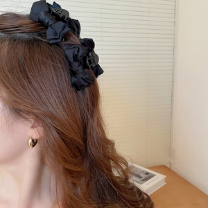 Fermagli a fiocco in raso nero su capelli lunghi mossi con orecchino a cuore dorato