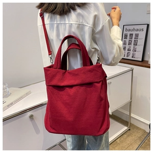 Detailed view of lightweight red nylon tote bag with dual handles and shoulder strap