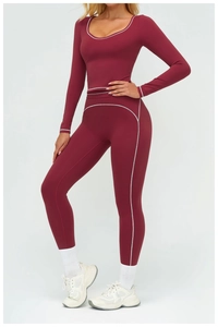 Dettaglio delle cuciture bianche a contrasto sul top da yoga bordeaux e sui leggings