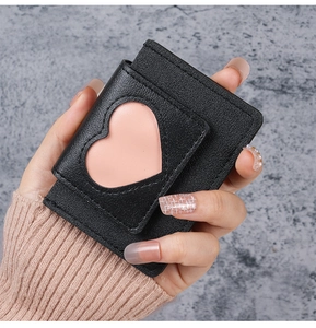 Close-up of black litchi pattern leather card holder with a pink heart window