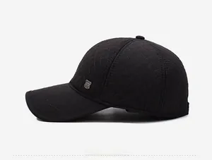 Détail d'une casquette de baseball noire matelassée à losanges avec logo en métal sur le côté