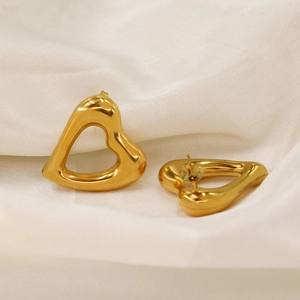 Minimalist 18K gold plated hollow heart stud earrings on elegant white silk background