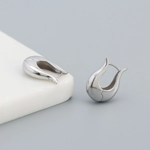 Detailed close-up of sterling silver streamlined earrings with a modern metallic finish