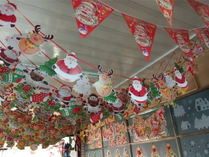 Hanging Christmas paper bunting with Santa Claus, reindeer, and festive tree patterns