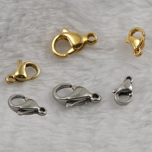 Detailed view of gold and silver stainless steel lobster clasps in three sizes on plush background