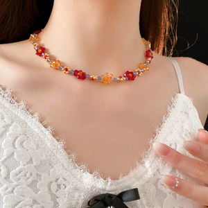 Détails du collier de fleurs perlées rouges et oranges avec des perles dorées et bleues