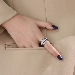 Three-piece stainless steel ring set with Roman numerals and crystals on a model hand