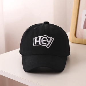 Detailed view of high-quality cotton canvas texture and 3D 'HEY' letter embroidery on the black cap