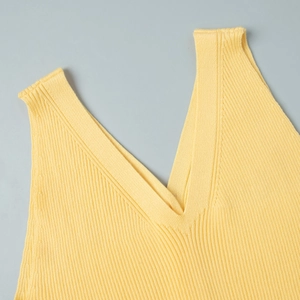 Gros plan détaillé du col en V en maille jaune avec texture à fines côtes