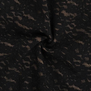 Macro detail of black floral lace fabric with nude lining and intricate textile texture