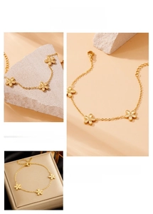 Detailed close-up of gold-plated five-petal flower charms on a minimalist dainty chain link