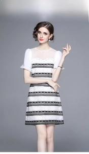Close-up of contrast lace mini dress with black scalloped trim and puff sleeves