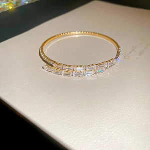 Macro shot of gold double-row baguette-cut zircon open bangle with sparkling light effects