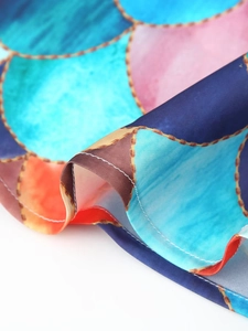 Detailed close-up of glossy satin fabric with colorful mosaic geometric patterns and gold stitching
