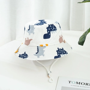 Détail d'un chapeau de soleil blanc pour enfants avec motifs dinosaures et cordon réglable