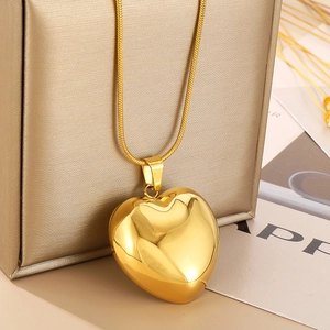 Detailed close-up of a polished gold heart pendant with a sleek snake chain necklace