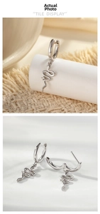 Detailed view of silver S-shaped snake charm earrings with a single crystal inlay