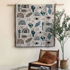 Bohemian blue and brown woven cotton picnic blanket hanging on a wooden rod