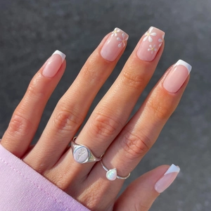 Minimalistische weiße französische Kunstnägel mit Blumendesign und rosa Basis