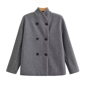 Détail d'un manteau en laine gris avec boutons noirs à double boutonnage et tissu fin