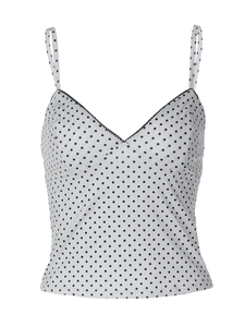 Detailed view of white camisole with black polka dots and wavy contrast trim