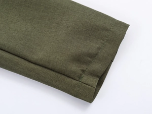 Gros plan sur la texture du tissu tissé vert et les détails de couture sur la manche