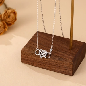 925 sterling silver infinity heart necklace with sparkling zircon on a wood stand