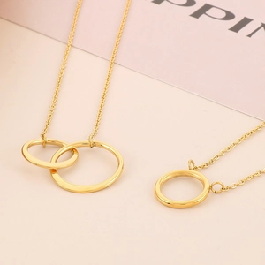 Detail of interlocking gold double circles and O-chain minimalist stainless steel necklace