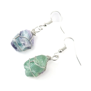 Detail of silver wire-wrapped natural fluorite crystal earrings with purple and green tones
