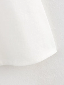 Detailed close-up showing the fine linen texture and neat stitching on white sleeve cuffs