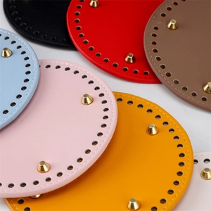 Close-up of 15cm round PU leather bag bases with pre-drilled holes and metal feet