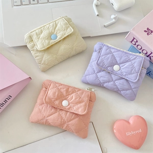 Detailed close-up of macaron-colored quilted coin purses and snap-button card holders