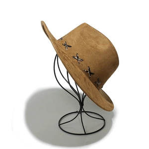 Faux suede western cowboy hat in camel with decorative silver X buckles on a stand