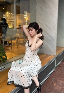 Detailed view of black lace trim on a white polka dot spaghetti strap midi dress