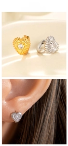 Détail de boucles d'oreilles cœur avec texture radiale et zircons en or et argent