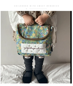 Close-up of floral canvas shoulder bag with white embroidered patch and retro design