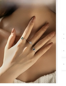 Detailed view of sterling silver rings featuring colorful oval gemstones on model hand