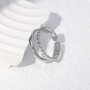 Close-up of double-layered silver ring featuring a beaded chain and wavy pattern band