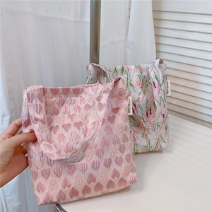 Detail of mini jacquard tote bags with pink floral and heart patterns for daily use