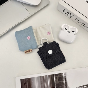 Detail view of denim earphone cases in blue and beige with snap closure and side label