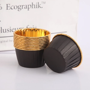 Detail of disposable black baking cups with gold rolled rim and vertical texture stripes
