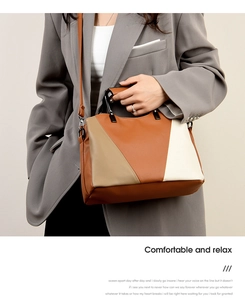 Detail of color-block tote bag with pebble leather texture on a grey suit model
