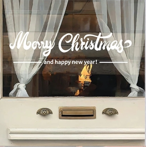 Close-up of white Merry Christmas and Happy New Year decals on a glass window pane