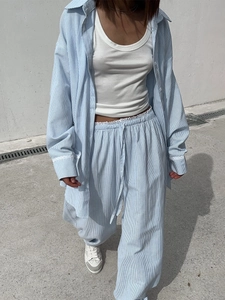 Detail showing white lace trim on sleeves and drawstring waist of blue striped loungewear set