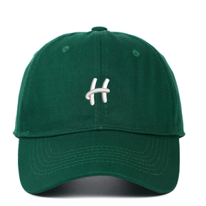 Close-up of deep green baseball cap with 3D white H letter embroidery detail