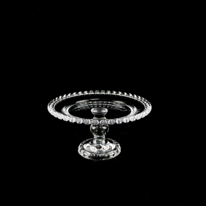 Detailed view of clear glass cake stand with beaded rim and elegant pedestal base