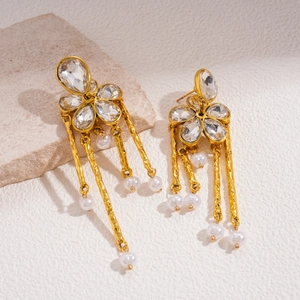 Detailed view of gold flower earrings with crystals, tassels, and hanging pearls