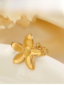 Detailed macro view of a golden five-petal flower ring with twisted rope band texture