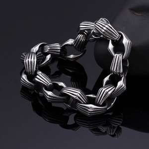 Dettaglio del bracciale a catena in acciaio argentato con riflesso su sfondo nero